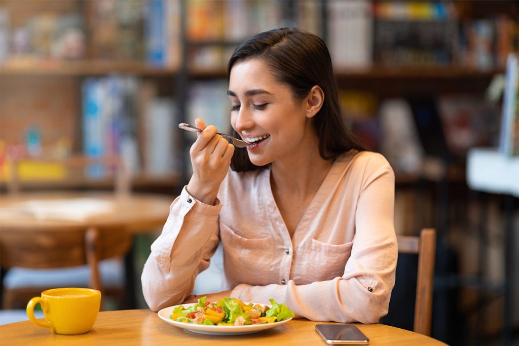 mujer comiendo saludable en restaurante